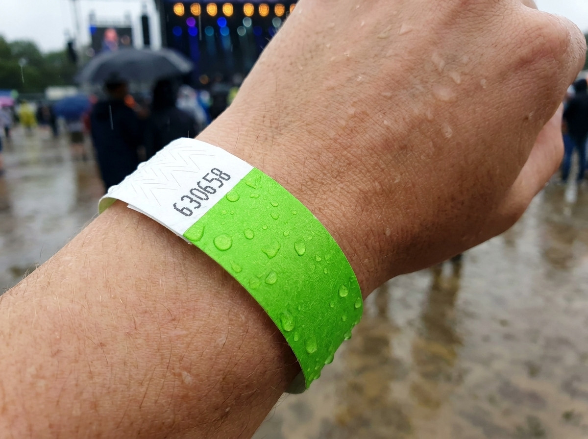 Identifikationsbånd båret om håndleddet i regn ved en udendørs festival der illustrerer dets vand- og fugttæthed