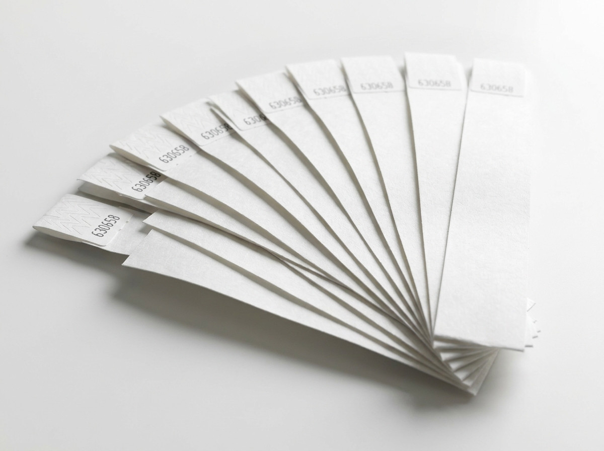 Sæt af hvide stive plastik-armbånd arrangeret som en vifte, klar til uddeling